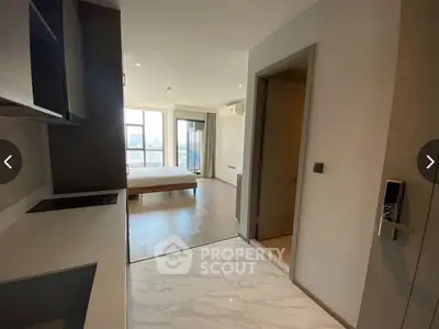 Spacious and modern apartment interior with sleek kitchen cabinets, gleaming marble floors, and abundant natural light from large windows leading to a cozy balcony.