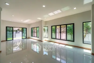 Spacious modern living room with large windows and glossy tiled floors