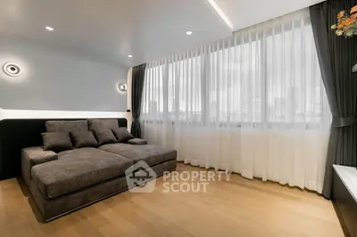 Modern living room with large windows and stylish gray sofa