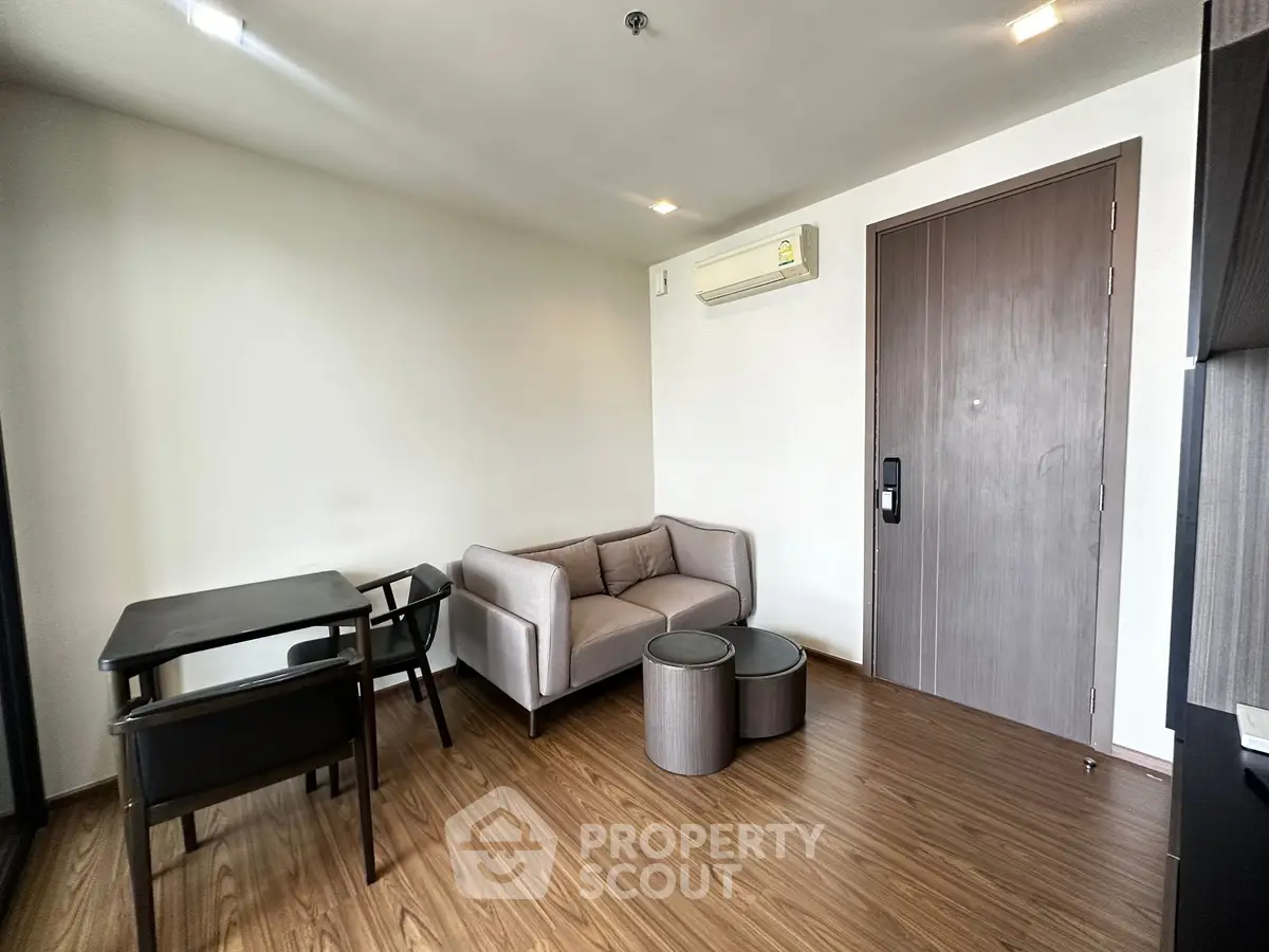 Modern living room with sleek furniture and wooden flooring in a stylish apartment.