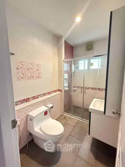 Modern bathroom with glass shower and sleek fixtures in a stylish home.
