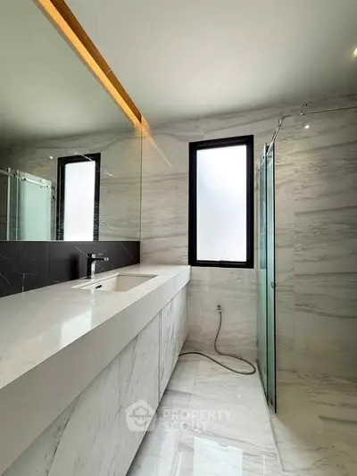 Luxurious modern bathroom with sleek marble finishes and large mirror