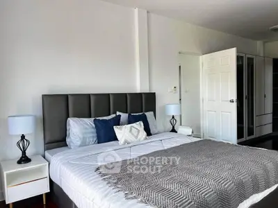 Spacious bedroom with modern decor and ample natural light, featuring a comfortable bed and stylish furnishings.