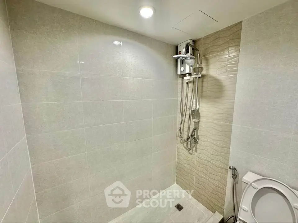 Modern bathroom with sleek shower and tiled walls in a contemporary home.