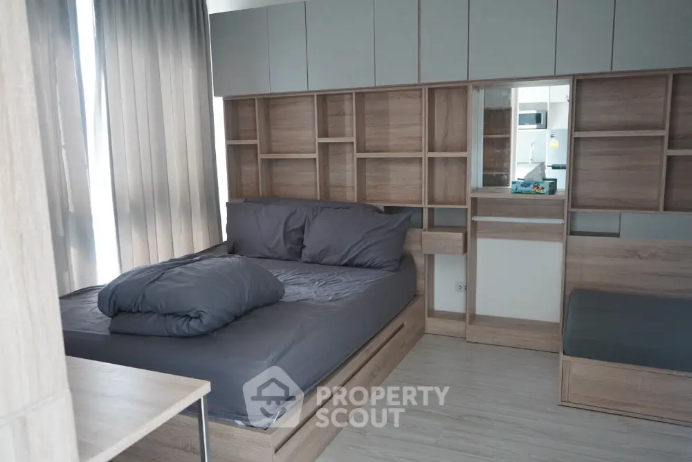 Modern bedroom with sleek wooden furniture and cozy gray bedding