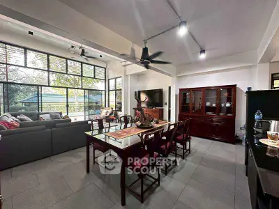 Spacious open-layout living and dining area with modern furnishings and large windows.