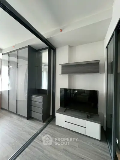 Modern living room with sleek TV unit and mirrored wardrobe doors