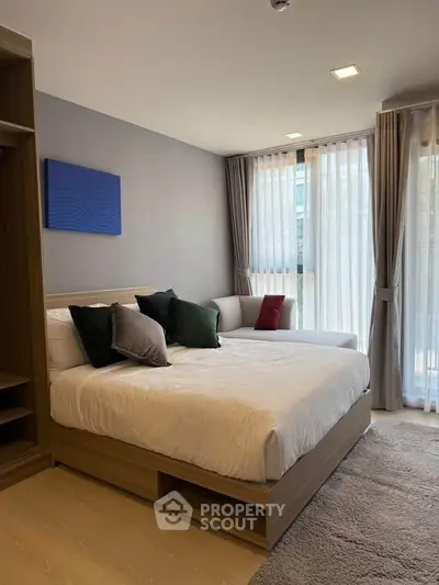 Modern bedroom with cozy bed and large windows in stylish apartment