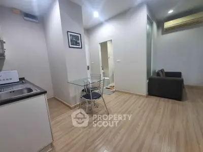 Modern apartment interior with open layout, featuring a compact kitchen and cozy living area.