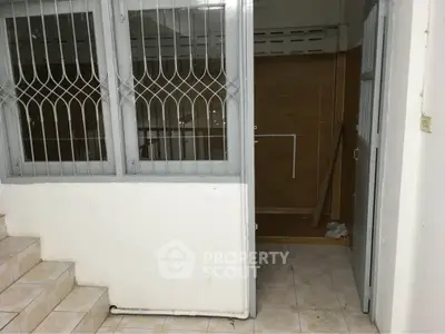 Spacious interior with tiled flooring and secure window grills, ideal for renovation.