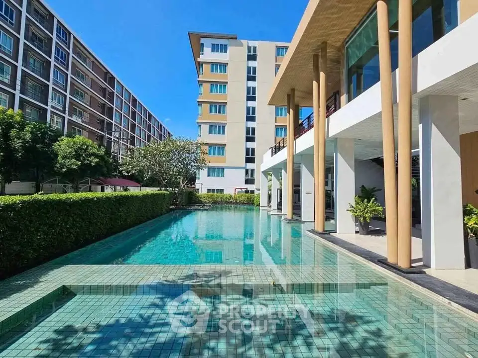 Luxurious apartment complex with a stunning outdoor pool and modern architecture.