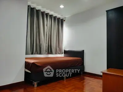 Cozy bedroom with wooden flooring and modern furnishings in a minimalist style.