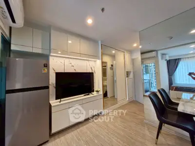 Modern living room with sleek design, featuring built-in TV unit and dining area in open layout.