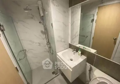 Modern bathroom with glass shower and sleek fixtures in a contemporary apartment.