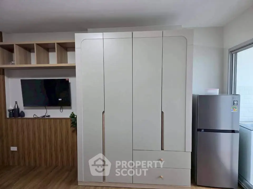 Modern apartment interior with sleek wardrobe and stainless steel fridge