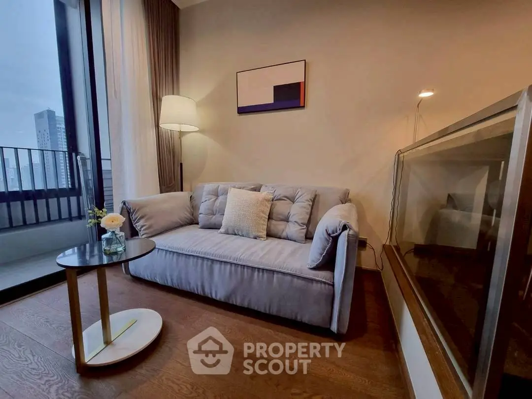 Modern living room with cozy sofa and elegant decor, featuring a city view balcony.