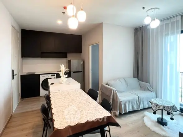 Modern open-layout kitchen and living room with stylish furniture and natural light.