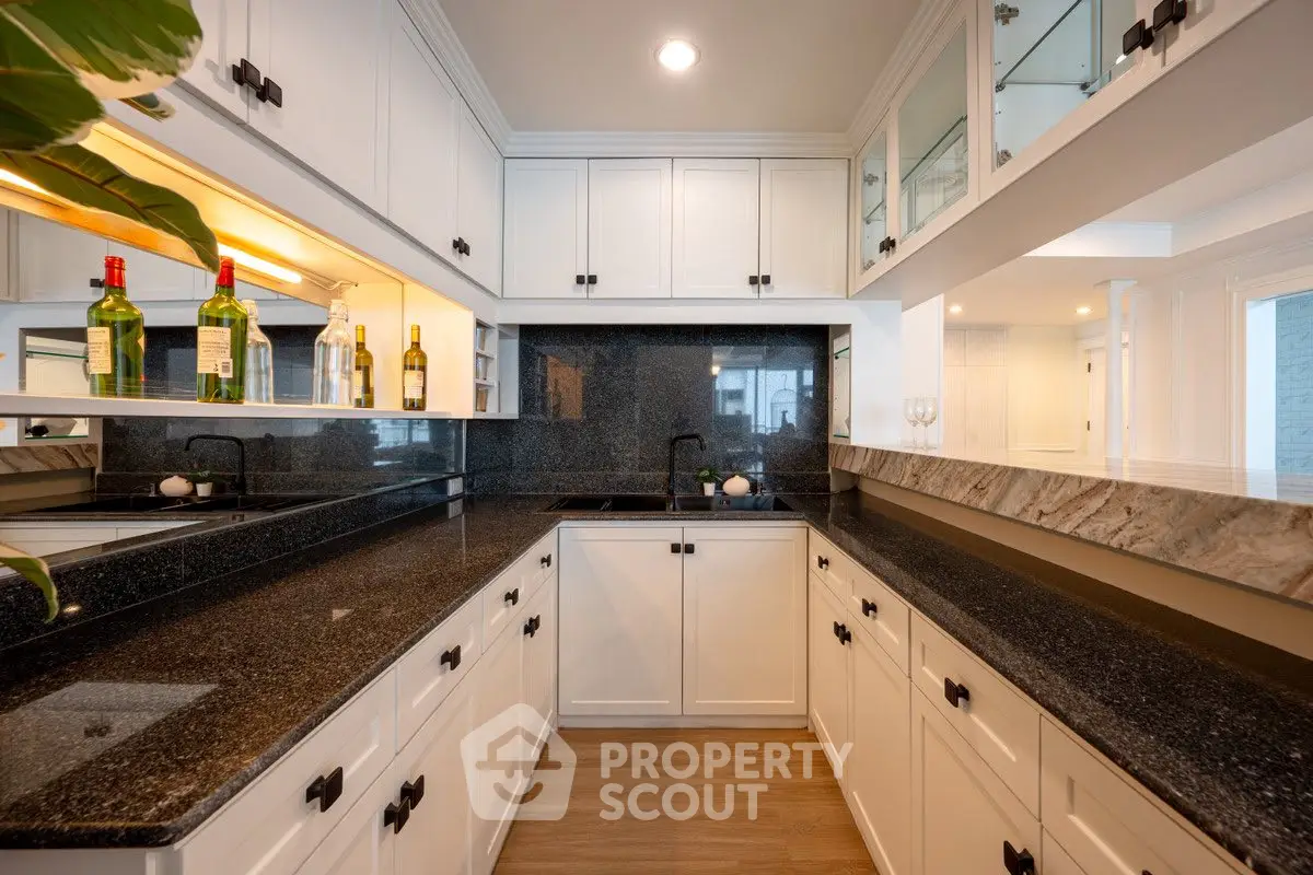 Luxurious kitchen with sleek black granite countertops and white cabinetry