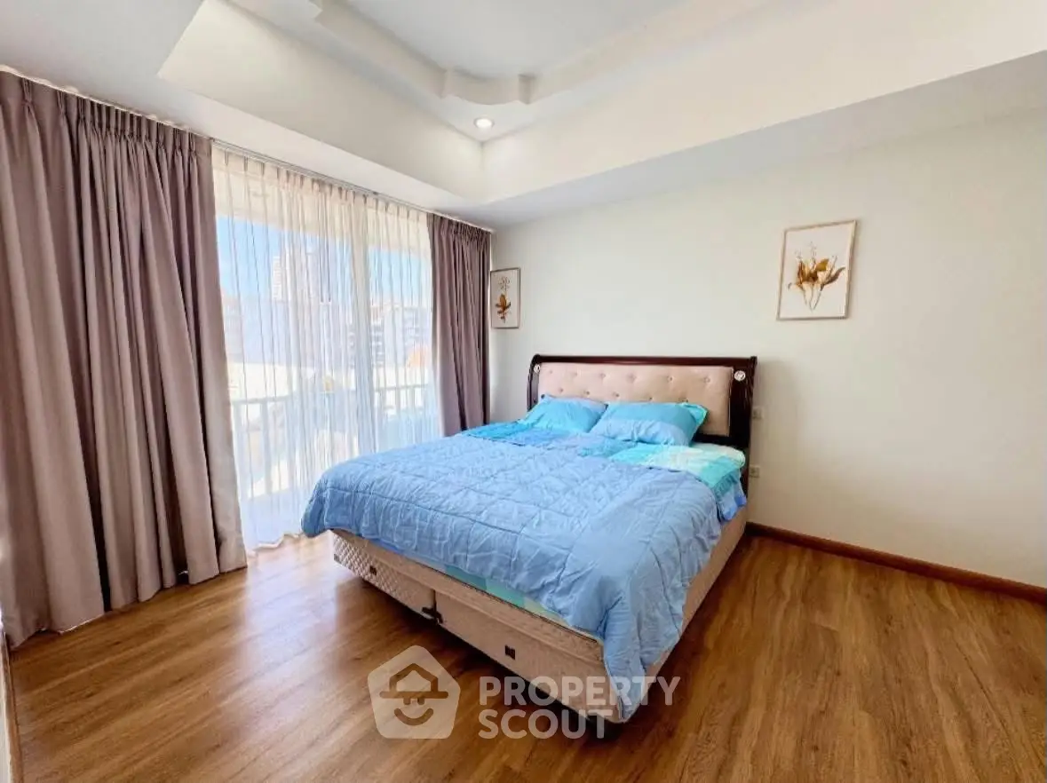 Spacious bedroom with large window and elegant decor in modern apartment