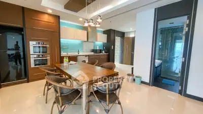 Modern kitchen with dining area, sleek appliances, and stylish lighting