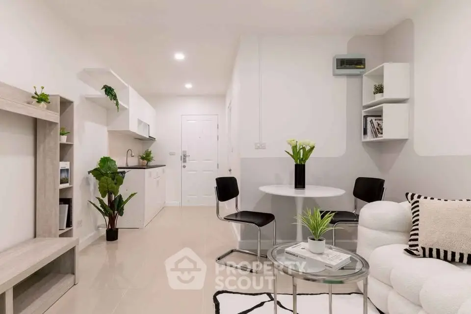 Modern living room with open kitchen, stylish furniture, and elegant decor in a cozy apartment.