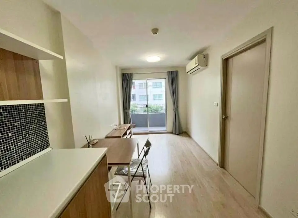 Modern living room with natural light and balcony view in a stylish apartment.