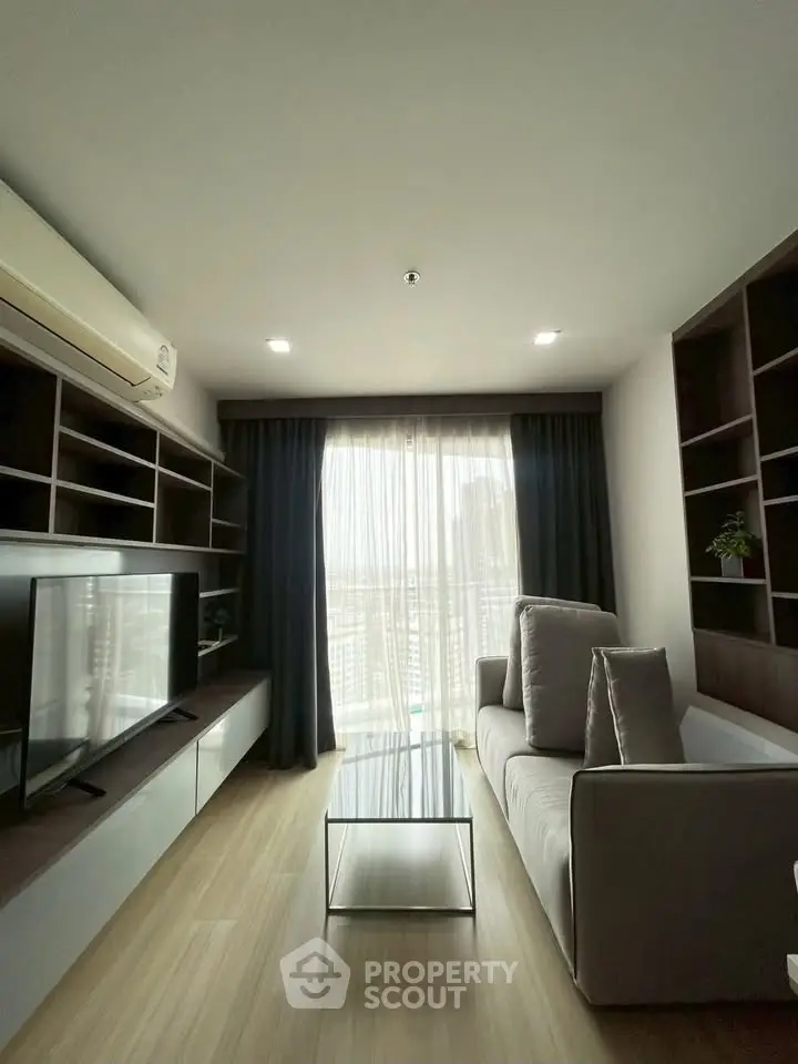 Modern living room with large window and stylish shelving in a high-rise apartment.