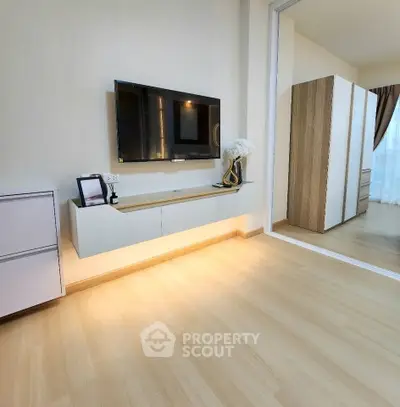 Modern living room with wall-mounted TV and elegant decor in a stylish apartment.