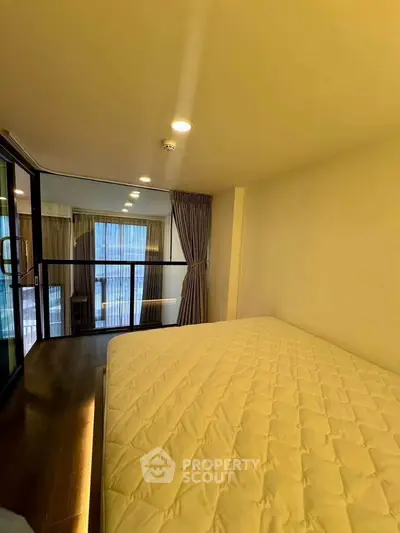 Spacious bedroom with large window and modern design in a luxury apartment.