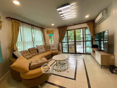 Spacious living room with modern decor and large windows offering natural light