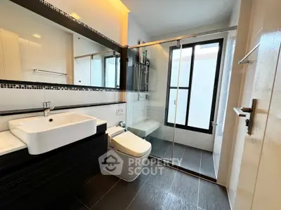 Modern bathroom with sleek design, glass shower, and stylish fixtures.
