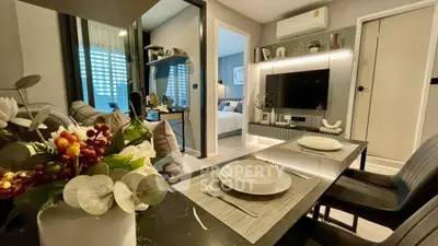 Modern living room with stylish decor and open view to bedroom, featuring sleek furniture and ambient lighting.