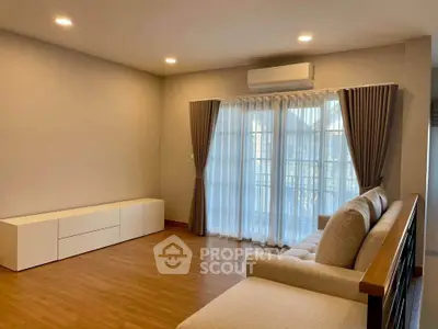Spacious living room with modern sofa and large window for natural light.