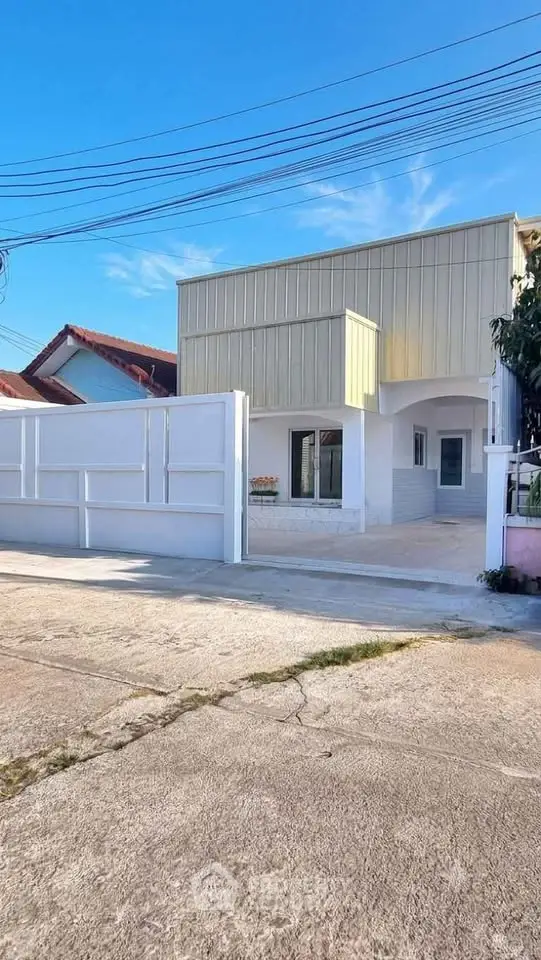 Modern two-story house with a minimalist facade and spacious driveway in a suburban neighborhood.