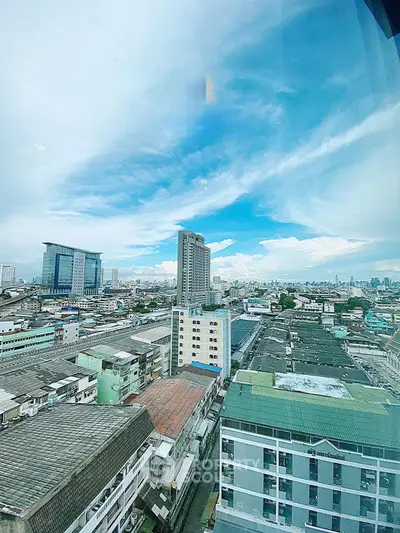 Stunning cityscape view from high-rise building showcasing urban skyline and clear blue sky.