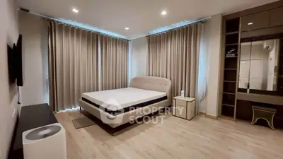 Spacious modern bedroom with elegant furnishings and ample natural light.