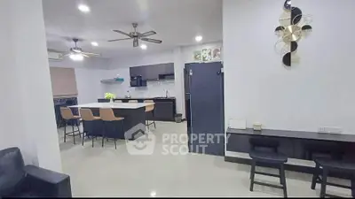 Spacious modern kitchen with island and sleek black appliances in open layout