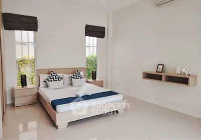 Spacious modern bedroom with minimalist decor and large windows