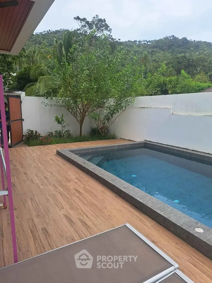 Luxurious outdoor pool area with lush greenery and mountain views, perfect for relaxation and entertainment.