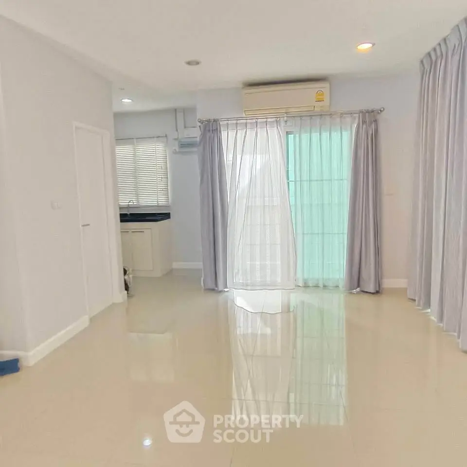 Spacious living room with glossy floors and large windows in modern home.