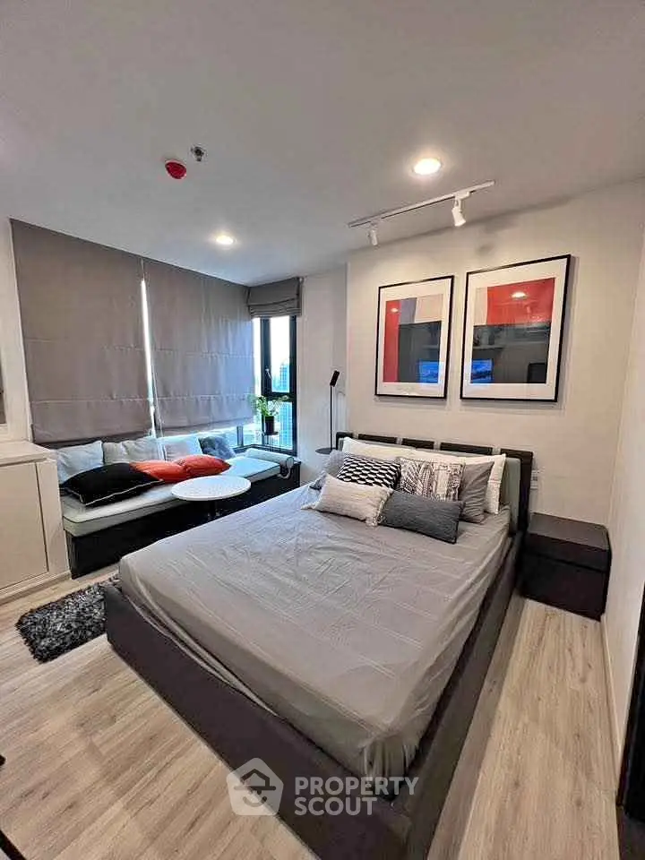 Modern bedroom with stylish decor and large windows in a contemporary apartment.