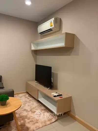 Modern living room with sleek TV unit and air conditioning, perfect for cozy relaxation.