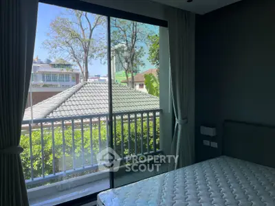Bright bedroom with large window and balcony view in modern home