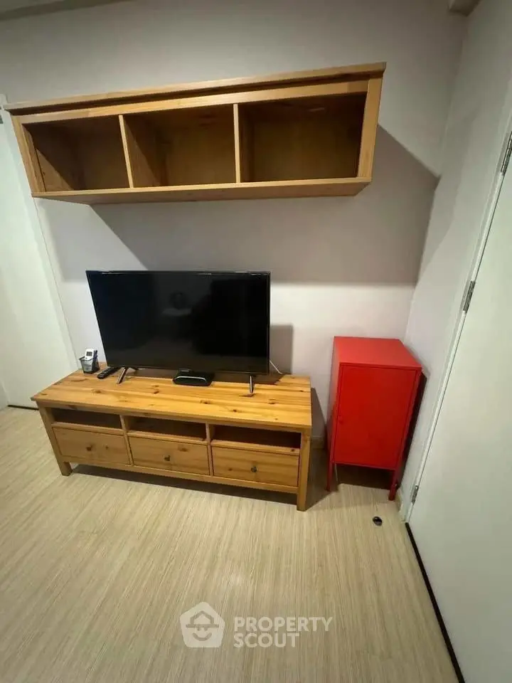 Cozy living room with wooden TV stand and wall-mounted shelves, perfect for modern living.