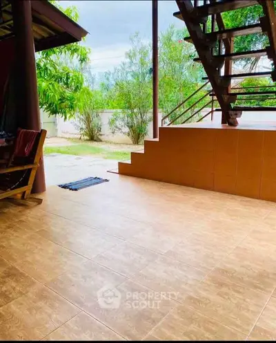 Charming outdoor patio with tiled flooring and staircase, perfect for relaxation and outdoor gatherings.