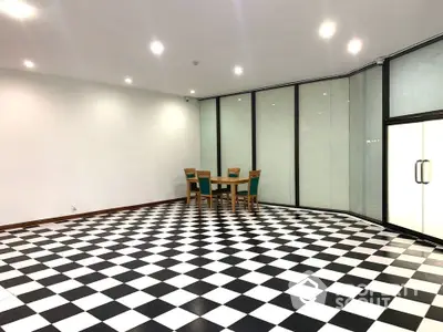 Spacious interior with checkered floor and glass walls, ideal for modern living or office space.