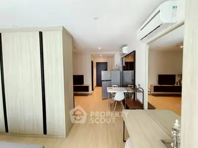 Modern open-plan living area with sleek kitchen and dining space, featuring contemporary furniture and neutral tones.