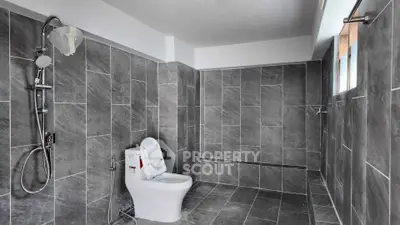 Spacious modern bathroom with sleek gray tiles and walk-in shower