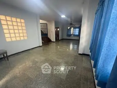 Spacious living room with large windows and tiled flooring, perfect for family gatherings.
