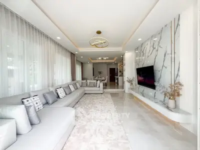 Luxurious modern living room with elegant marble wall and spacious seating area.